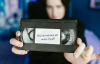 Frau hält VHS-Kassette in den Händen mit der Aufschrift "Und wir nehmen uns unser Recht"